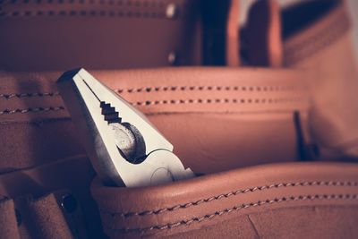 Close-up of pliers in leather pocket