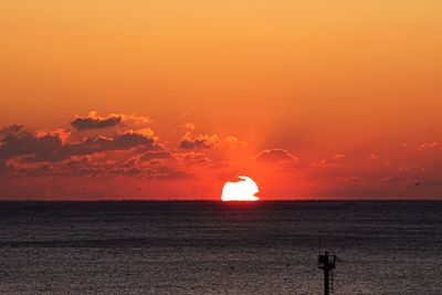 Scenic view of sea against orange sky
