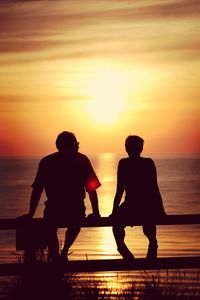 Silhouette of people on beach at sunset