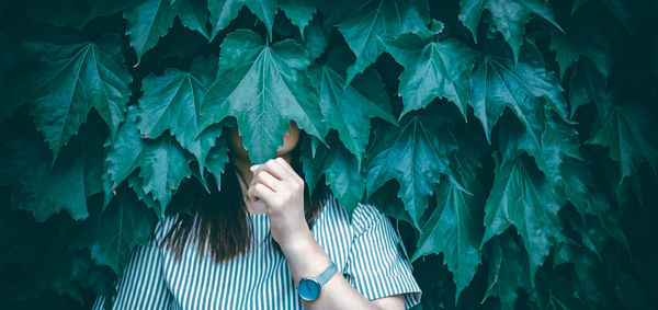 Low section of woman standing by leaves