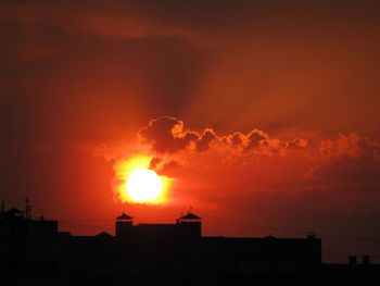 Silhouette city against sky during sunset