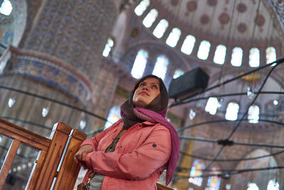 Low angle view of woman standing against ceiling