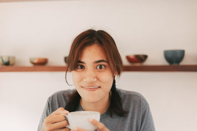 Portrait of young woman drinking coffee