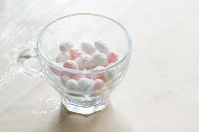 High angle view of marshmallows in glass cup on table