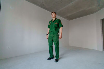 Full length of soldier standing against wall