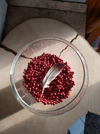 A sea gull feather in a bottle of little red marbles