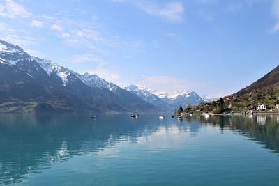 Scenic view of lake and snowcapped mountains against sky