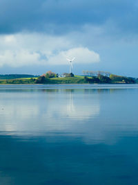 Wind mill reflected in calm sea