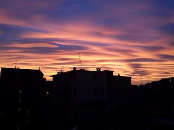 Silhouette cityscape against sky during sunset