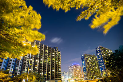 Low angle view of illuminated buildings against sky in city