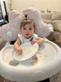 High angle view of cute baby girl eating rice 