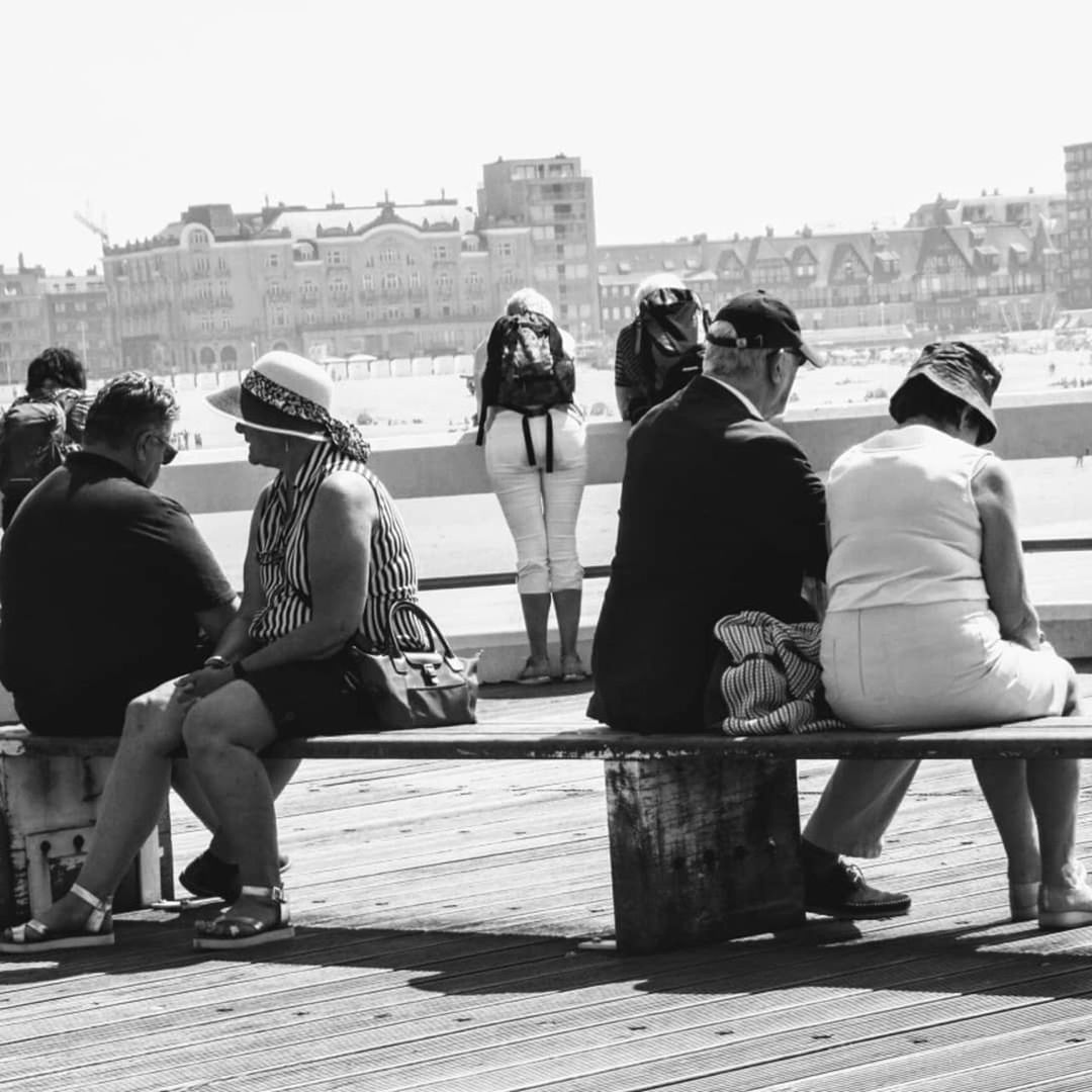 men, group of people, built structure, architecture, real people, rear view, building exterior, day, city, nature, water, sitting, sky, people, adult, leisure activity, sunlight, lifestyles, women, outdoors, looking at view