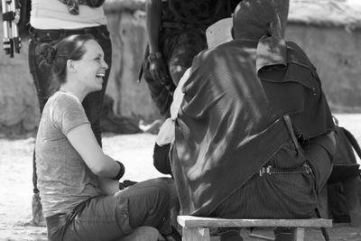 Young woman smiling by masai man on footpath