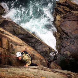 Directly above portrait of smiling man climbing on rock formation