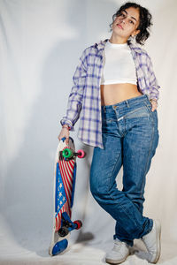 Young woman standing against wall