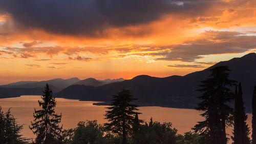 Scenic view of silhouette mountains against orange sky