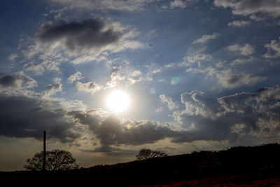 Silhouette of trees against cloudy sky