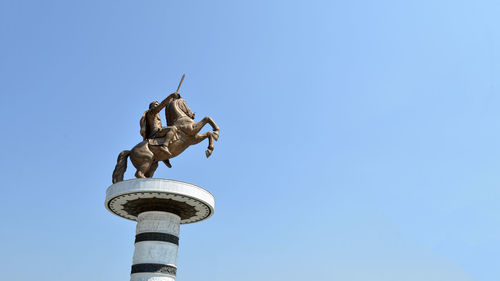 Low angle view of statue against blue sky