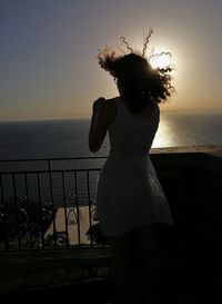 Rear view of woman looking at sea against sky