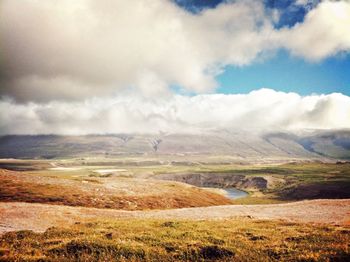 Scenic view of landscape against cloudy sky