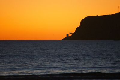 Scenic view of sea against orange sky