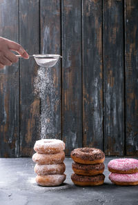 Close-up of woman icing donuts on table