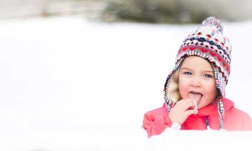 Portrait of cute girl on snow covered field during winter