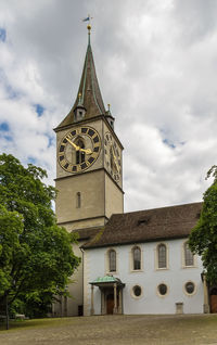 Low angle view of clock tower by building against sky