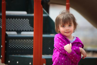Portrait of cute smiling girl standing at playground