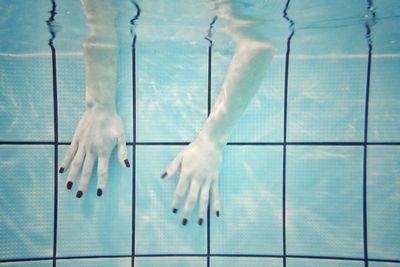 Close-up of hands with nail polish dipped in swimming pool