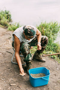 A young fisherman catches fish on a lake or river, prepares tackle and bait. hobbies