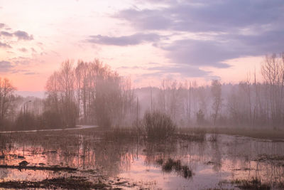 Scenic view of lake against sky at sunset