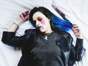 Portrait of young woman lying down on bed
