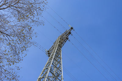 Low angle view of electricity pylon against clear sky