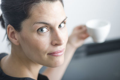 Portrait of woman holding coffee cup at home