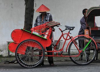 Bicycle standing on street against red background