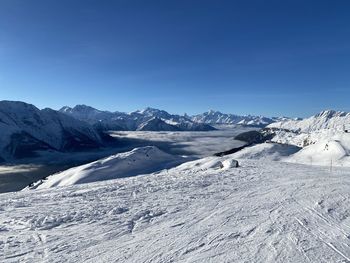 Scenic view of snowcapped mountains against clear blue sky