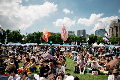 Group of people in city against sky