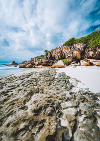 Rocks at beach against sky