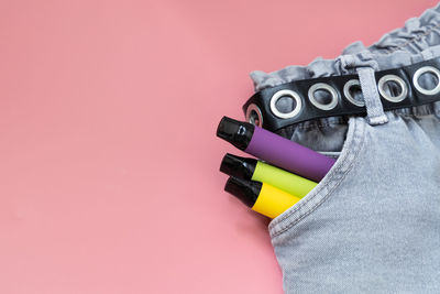 Cropped image of man wearing gloves against pink background