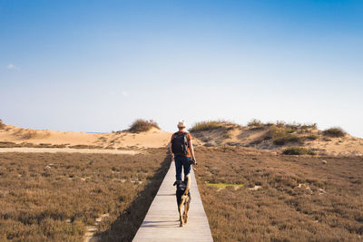 Man riding bicycle on road against sky