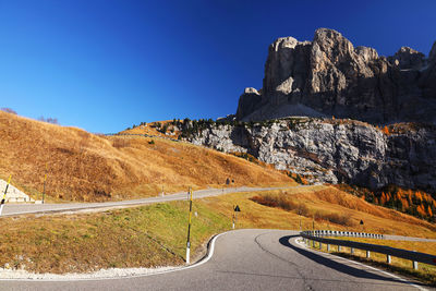 Road by mountain against blue sky