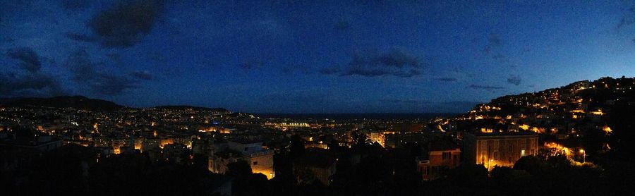 Illuminated cityscape against sky at night