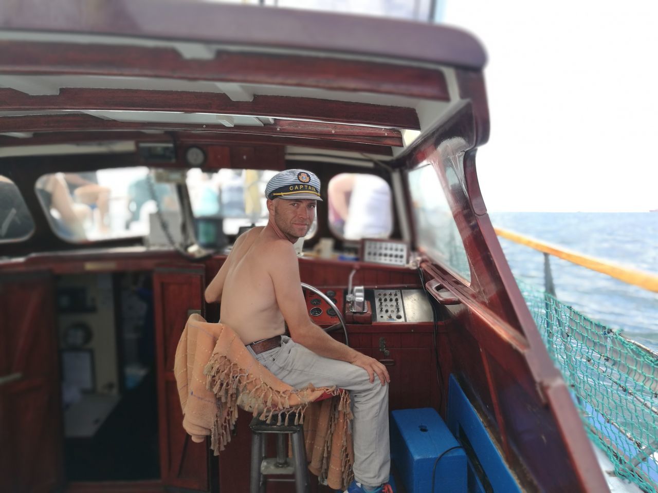 transportation, one person, mode of transport, nautical vessel, real people, sea, mid adult men, shirtless, standing, day, outdoors, men, cap, occupation, lifestyles, nature, young adult, people