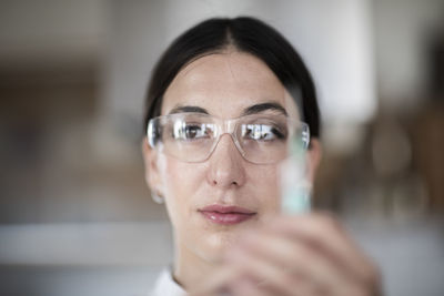 Scientist female with lab glasses, tablet and sample in a lab