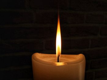 Close-up of lit candle in darkroom