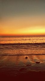 Scenic view of beach against clear sky during sunset