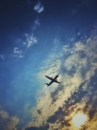 Low angle view of silhouette airplane against sky