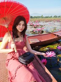 Portrait of beautiful young woman holding pink flower