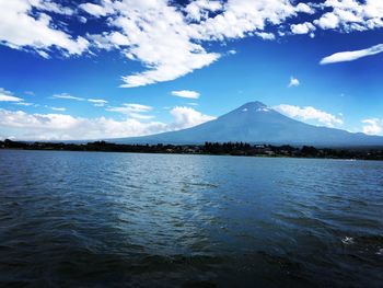 Scenic view of lake and mountains against blue sky